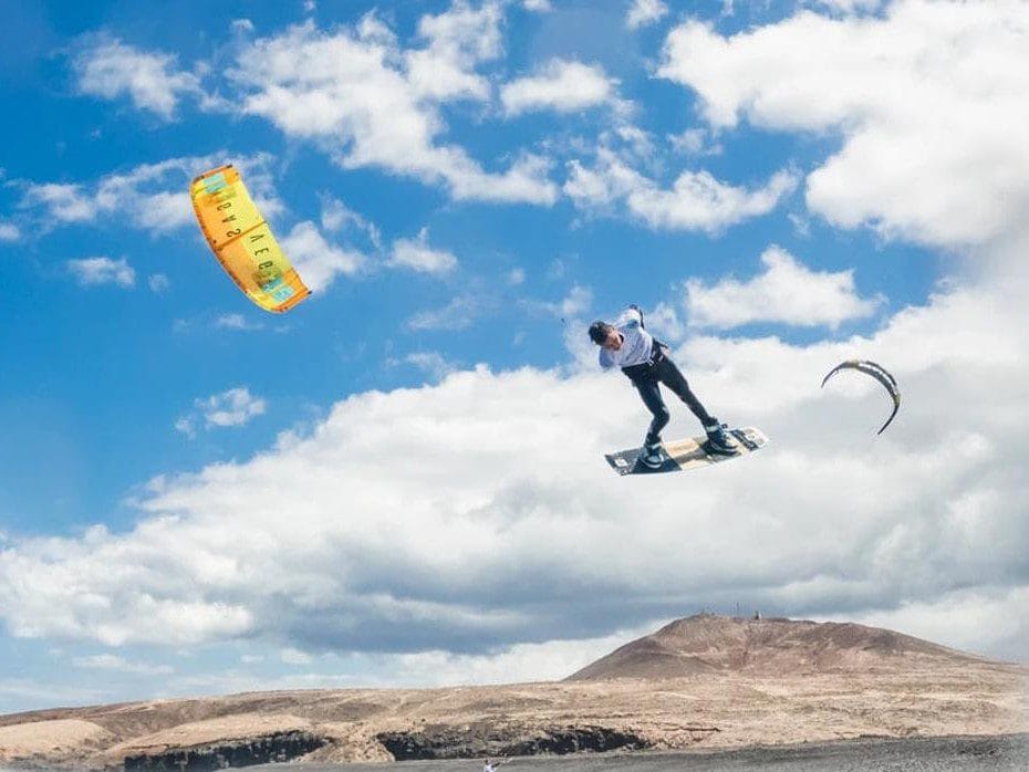 Vista de una persona haciendo un salto increible mientras hace kitesurf en Gran Canaria