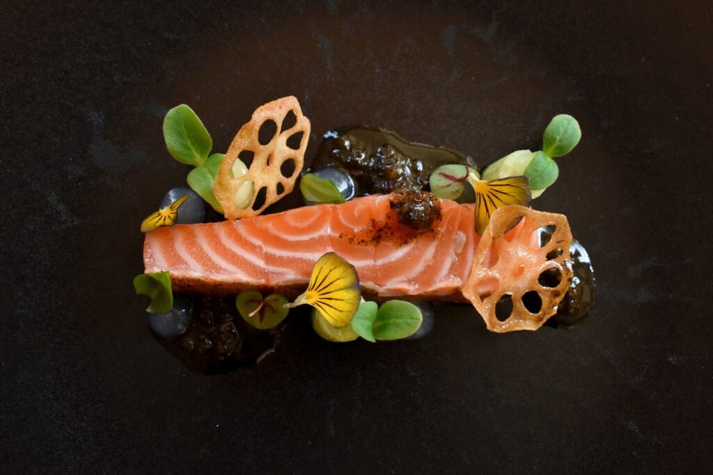 Preparación creativa de un trozo de salmón en restaurante Michelín