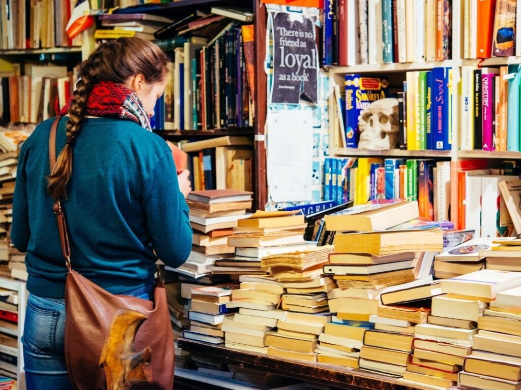 Vista de una chica mirando libros de segunda mano en una libreria