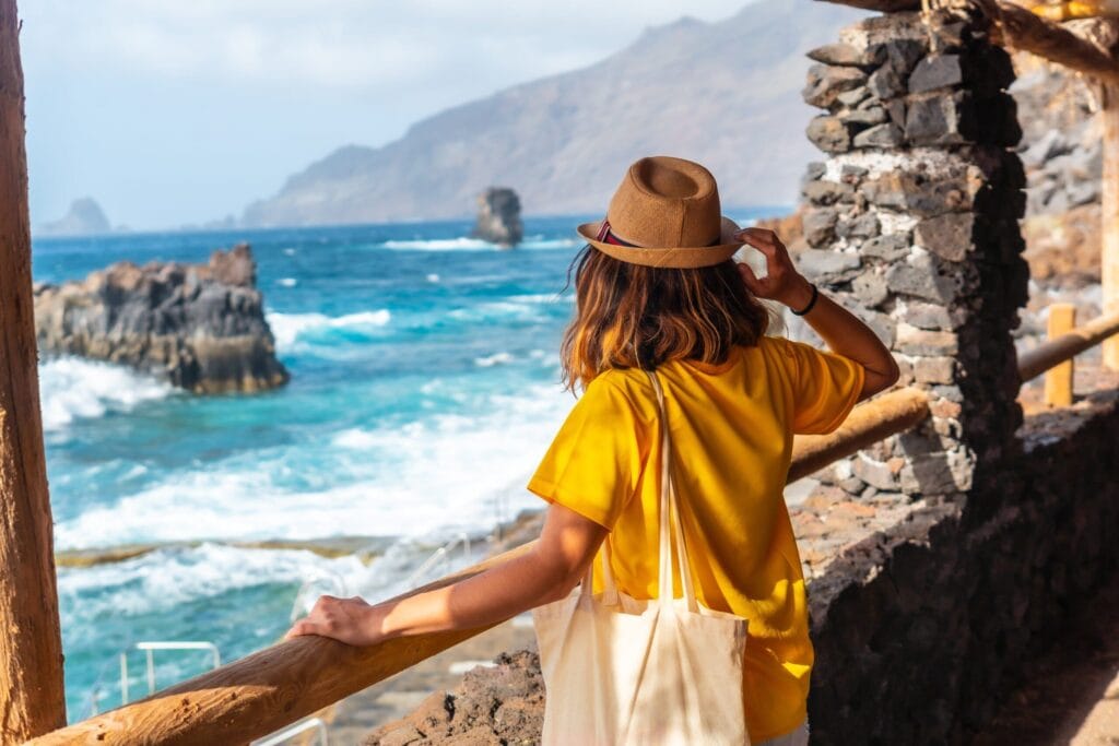 Vista de una turista disfrutando las vistas de la piscina la Maceta en El Hierro