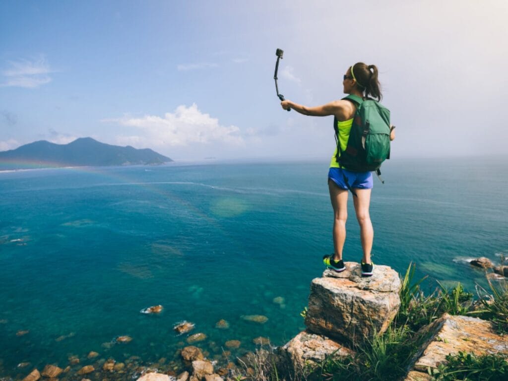 Vista de una chica haciendose una foto con una camara, uno de los objetos que llevar en tu equipaje a las Islas Canarias