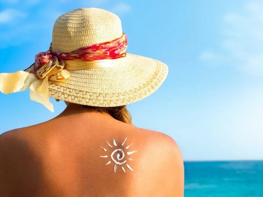 VIsta de una chica con protector solar en la espalda, uno de los elementos que llevar a las Islas Canarias